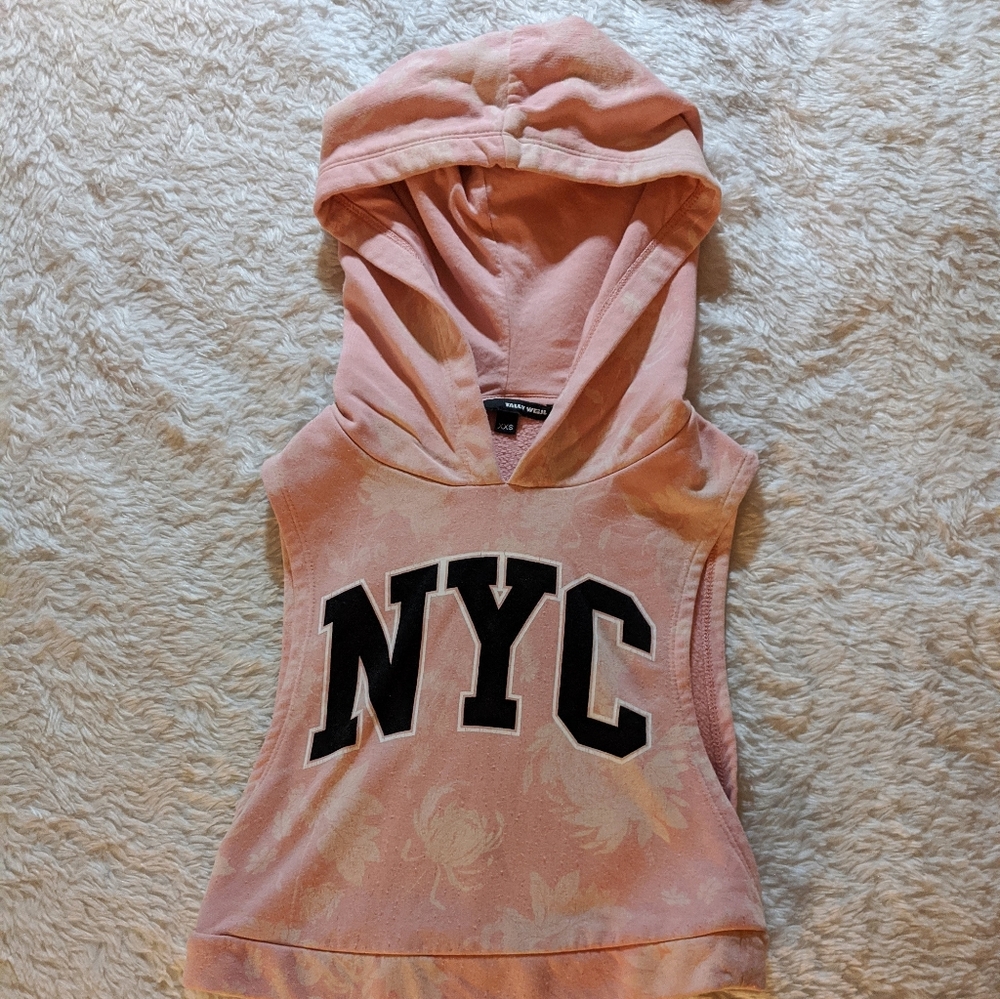 A sleeveless pink sweatshirt with flowers on it.